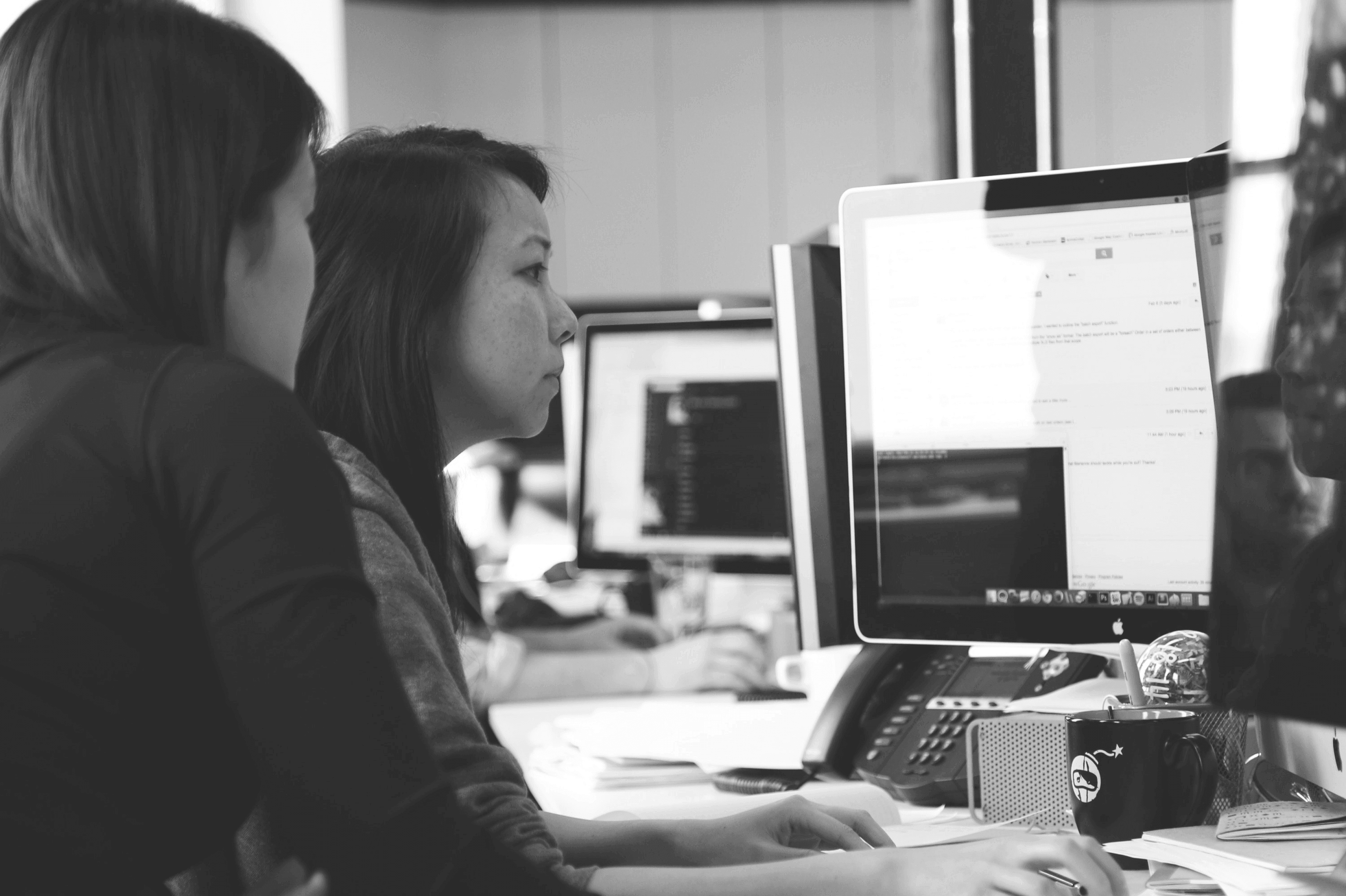 people working together at a desk looking at a screen